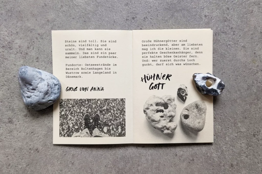 Echte Steine halten das Heft aufgeklappt, Abbildung mit Hühnergöttern