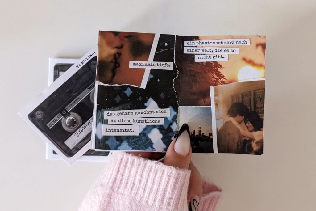 Hand mit hellrosa Ärmel hält das aufgefaltete Zine. Sichtbar ist eine Collagen-Seite mit melancholisch-nostalgischen Fotoschnipseln (Sonne scheint durch Bäume, Menschen küssen sich, angeblitzte Schneeflocken) und aufgeklebten Textfragmenten.