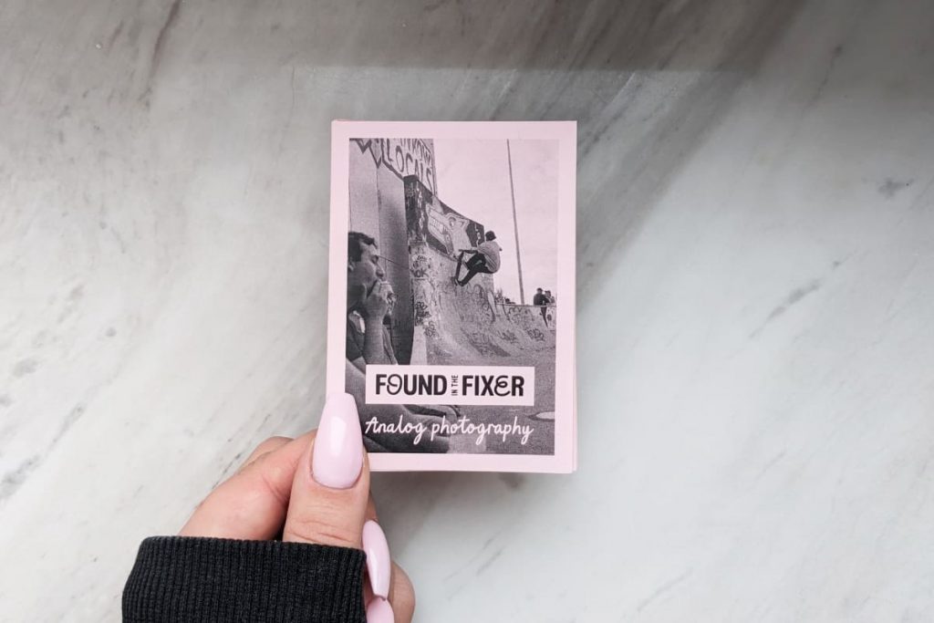 Hand mit rosa Fingernägeln hält ein rosa Mini-Zine. Titel „Found in the Fixer“ mit einem Foto eines Skaters in einer Halfpipe.