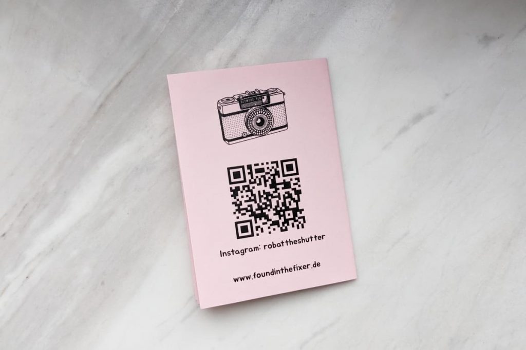 Rückseite des Zines mit Kamera-Illustration, QR-Code, Instagram und Website-URL.