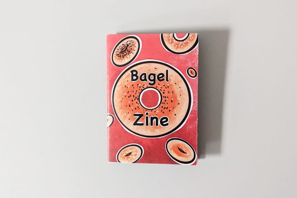 Cover eines roten Zines mit der Aufschrift „Bagel Zine“ und Illustrationen von verschiedenen Bagels im Comic Stil.