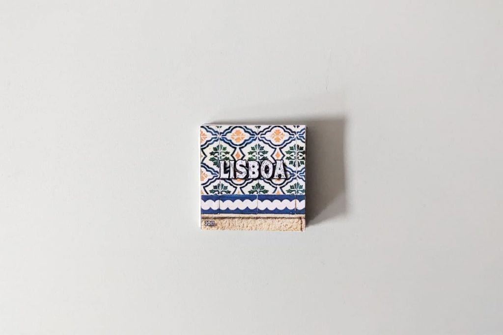 Kleines, quadratisches Zine mit der Aufschrift „LISBOA“. Im Hintergrund ein Foto von traditionellen portugiesischen Fliesen.