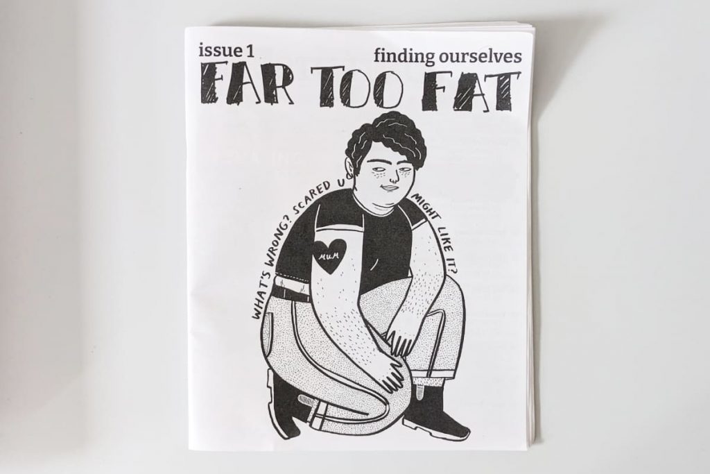 Schwarz-Weiß-Cover des Zines „Far Too Fat“ mit Illustration einer hockenden Person mit Kurzhaarschnitt, die verschmitzt guckt und dem Text "Whats wrong? Scared you might like it?"