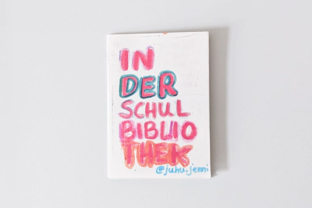 Handgezeichnetes weißes Cover mit der bunten kindlichen Aufschrift „In der Schulbibliothek“ und "juhu.jenni".