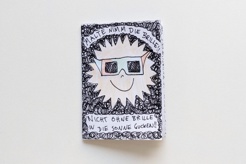 Handgezeichnetes Zine zur Sonnenfinsternis mit der Aufschrift „Malte nimm die Brille!“.