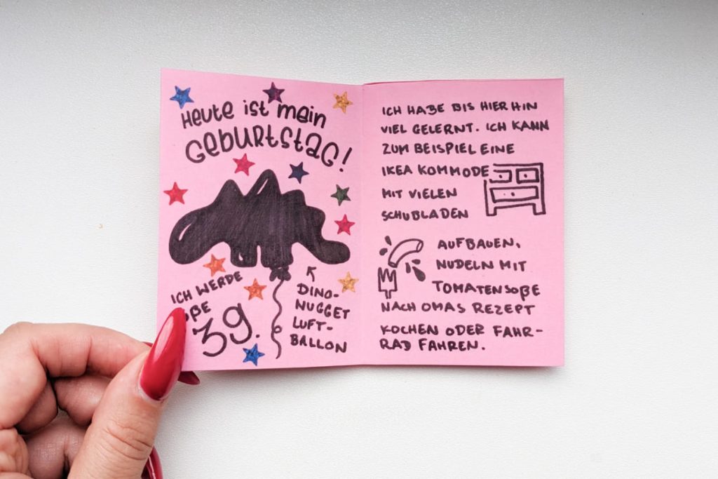 Offenes Zine: Texte handgeschrieben, einfarbige einfache Illustration eines Dino-Nugget-Luftballons, einer Kommode und einer Makkaroni-Nudel.
