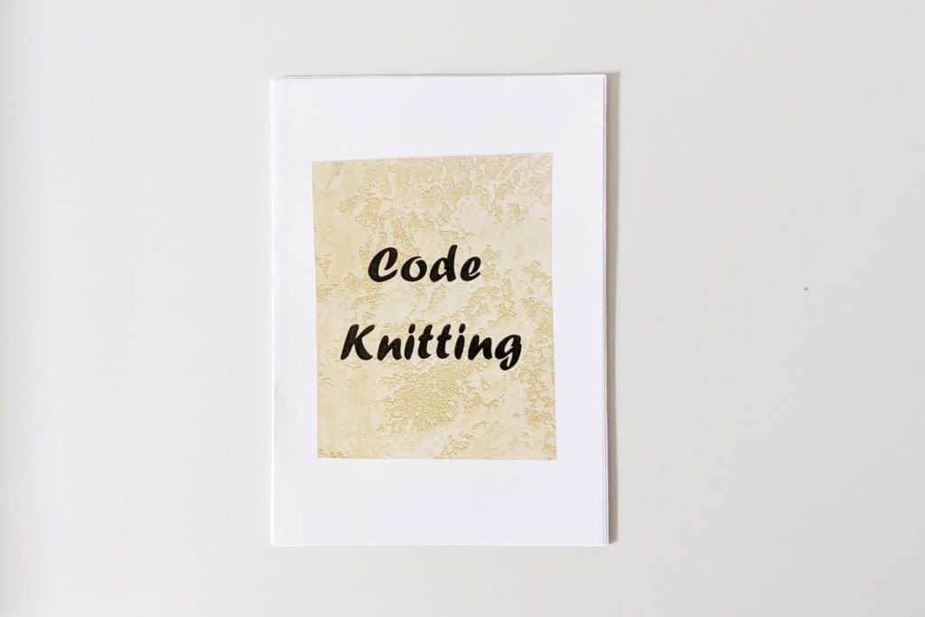 Handgemachtes Zine, Cover schwarze Schrift "Code Knitting" auf beige texturiertem Hintergrund